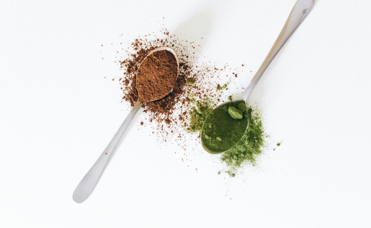 cacao - muỗng bột cacao và bột matcha đặt bên cạnh nhau