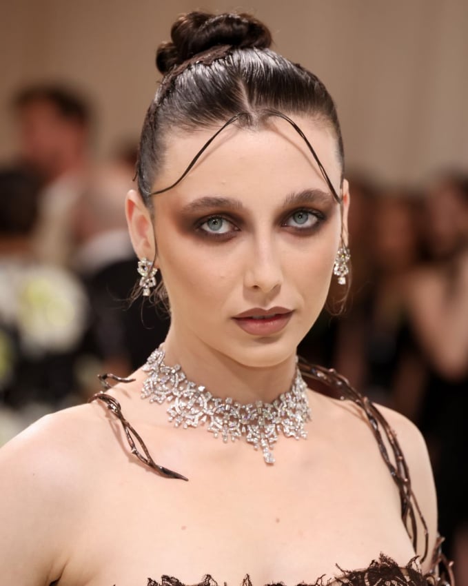 Emma Chamberlain cũng chọn phong cách phản diện và đã chinh phục thành công. Đường kẻ mắt nâu nhòe, mái tóc búi bóng mượt cùng đôi môi được kẻ viền chuẩn xác đầy cá tính.