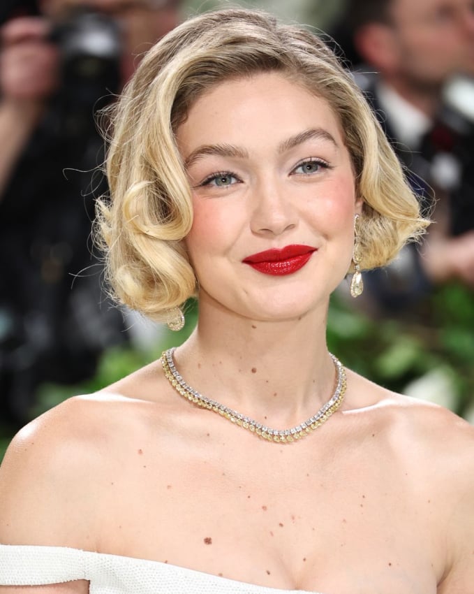Gigi Hadid gợi nhắc đến hình ảnh của minh tinh Marilyn Monroe với màu son đỏ rực rỡ. Để phù hợp với phong cách mùa xuân, Gigi Hadid trang điểm mắt nhẹ nhàng, tinh tế
