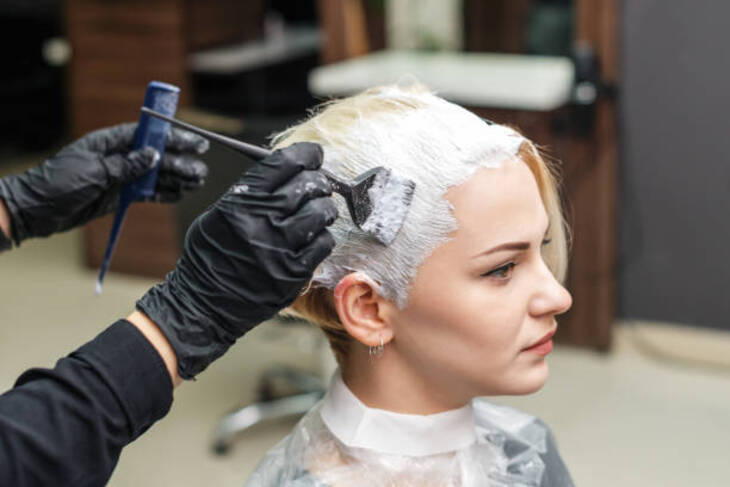 Cô gái đang tẩy tóc ở salon.