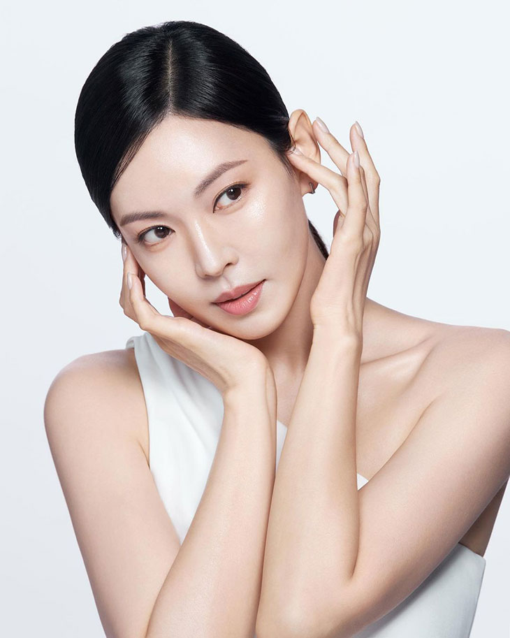 Người phụ nữ chạm tay lên hai bên khuôn mặt.